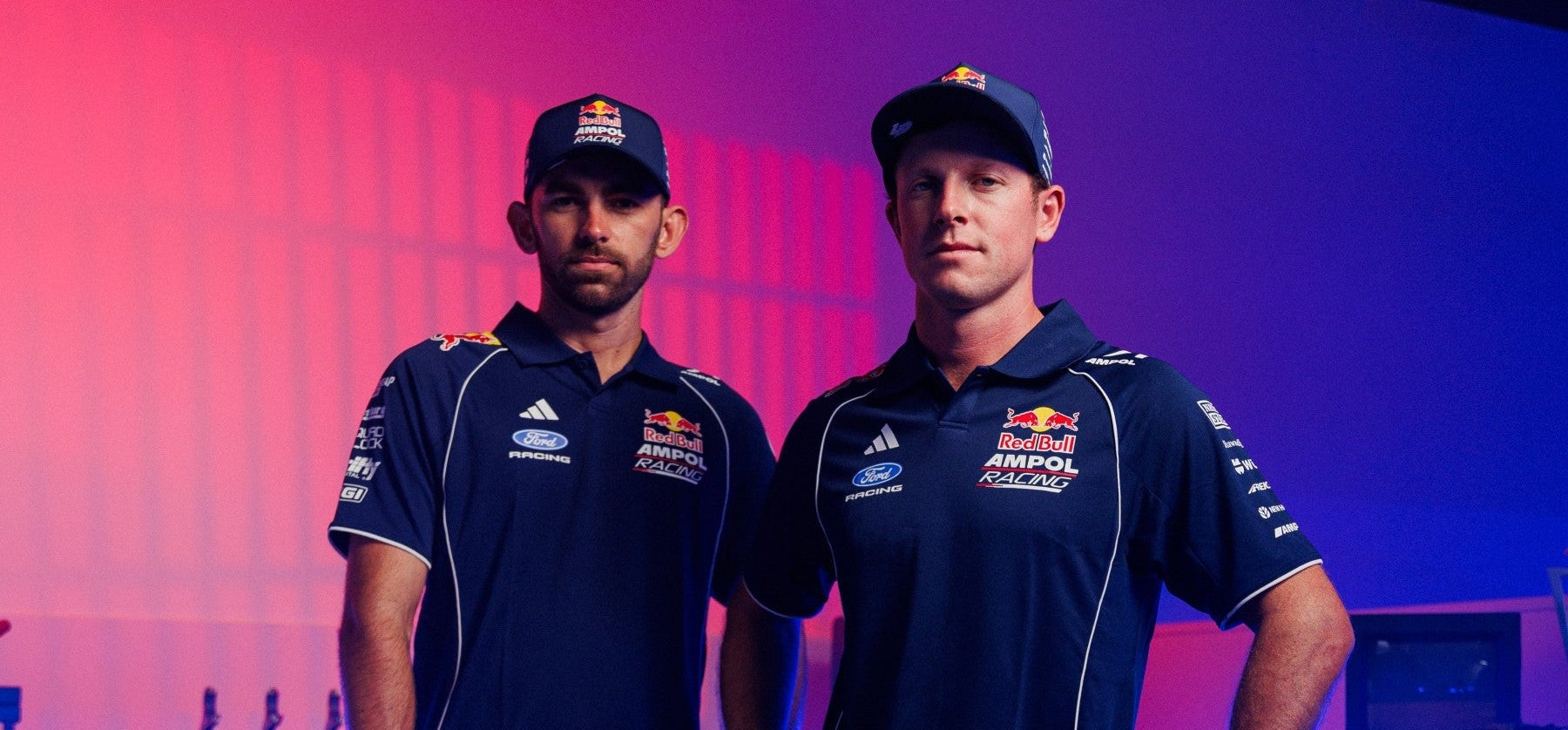 Red Bull Ampol Racing Image of Drivers Broc and Will wearing new RBAR x adidas polo shirts and locked down cap race merchandise.